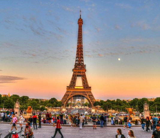 Mann klettert auf den Eiffelturm und springt mit einem Fallschirm von der Spitze des Turms Eiffelturm