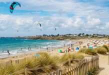 Kitesurfen in Saint-Pierre-Quiberon: Zwischen Freiheit auf dem Wasser und Grenzen am Strand Sommertag-am-Strand-mit-Kitesurfern_Illustration