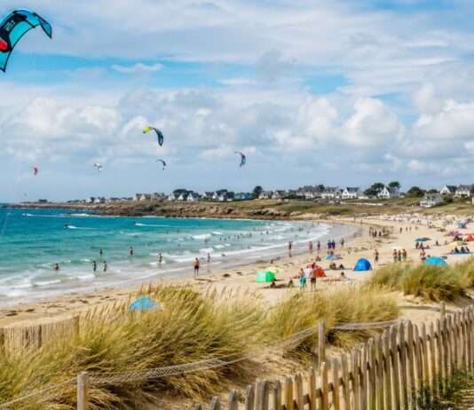 Kitesurfen in Saint-Pierre-Quiberon: Zwischen Freiheit auf dem Wasser und Grenzen am Strand Sommertag-am-Strand-mit-Kitesurfern_Illustration