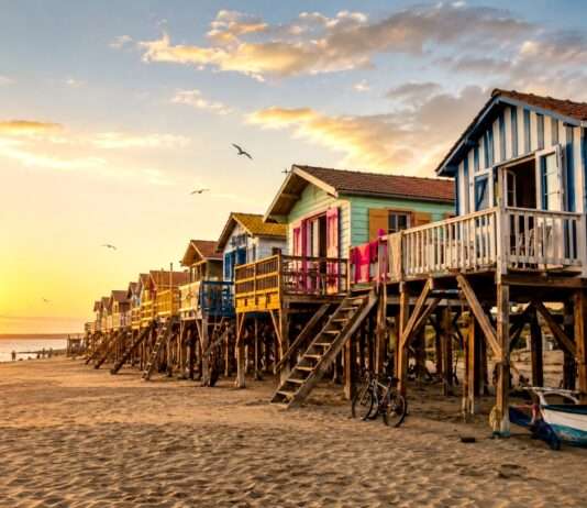 Holz im Wind Bunte-Strandhäuser-im-warmen-Sonnenlicht